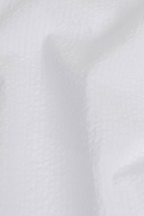 Close-up texture of a white seersucker skirt fabric.